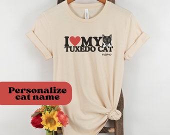 May include: A beige t-shirt with the text "I love my tuxedo cat" and a black and white tuxedo cat graphic. The text "name" is below the graphic.