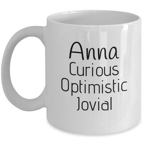 Puede incluir: Taza de caf&eacute; de cer&aacute;mica blanca con texto negro que dice "Anna Curious Optimistic Jovial".
