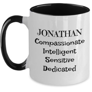 May include: White ceramic coffee mug with a black rim and handle. The mug has black text that reads "JONATHAN Compassionate Intelligent Sensitive Dedicated".