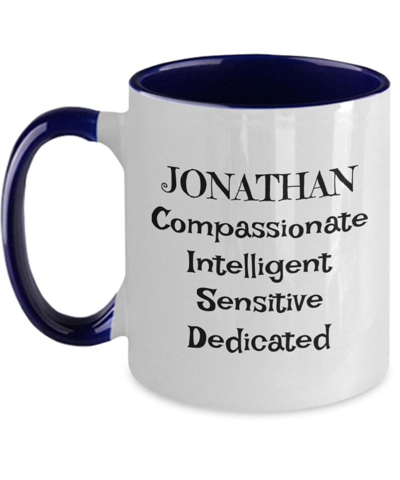 May include: White ceramic coffee mug with a blue rim and handle. The mug has black text that reads "JONATHAN Compassionate Intelligent Sensitive Dedicated".