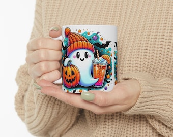 May include: White ceramic mug featuring a cartoon ghost wearing an orange knit cap, holding a pumpkin, and a drink with a straw. The mug has a Halloween theme with bats and stars.