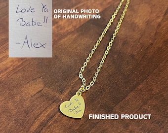May include: A gold chain necklace with a heart-shaped pendant. The pendant has the handwritten message "Love Ya Babe!! -Alex" engraved on it.