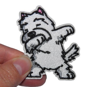 Peut inclure: Patch brodé blanc à repasser représentant un chien blanc faisant le dab. Le chien a les yeux noirs et le nez noir.
