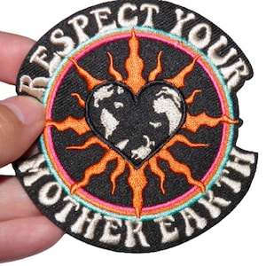 May include: A black embroidered patch with a white outline. The patch features a sun with a heart-shaped earth inside. The text "Respect Your Mother Earth" is written around the sun.