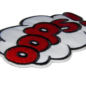 May include: A white cloud-shaped patch with the word "OOPS!" in red letters with black outlines.