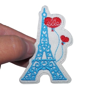 Puede incluir: Parche azul bordado para planchar con la Torre Eiffel y dos globos rojos en forma de corazón, uno con la palabra "Ella" en él.