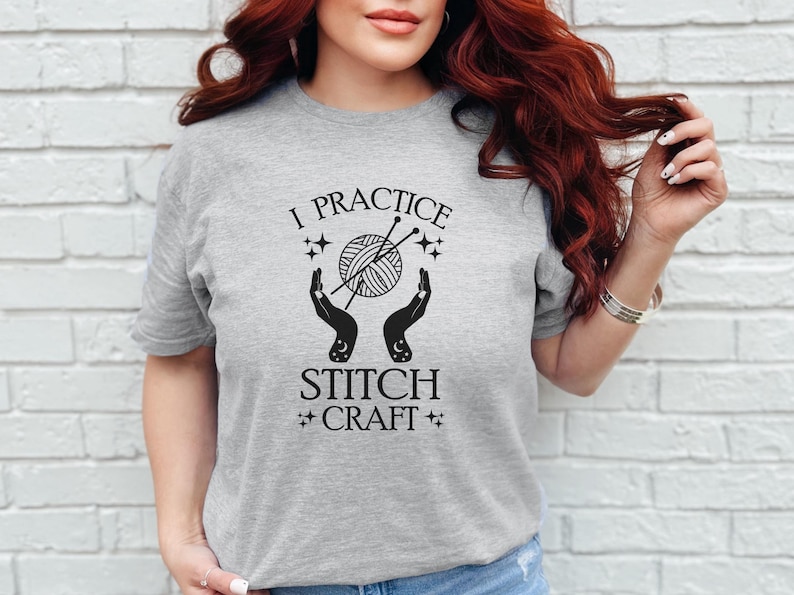 May include: A gray t-shirt with the text "I practice stitch craft" and a graphic of hands holding yarn and knitting needles.