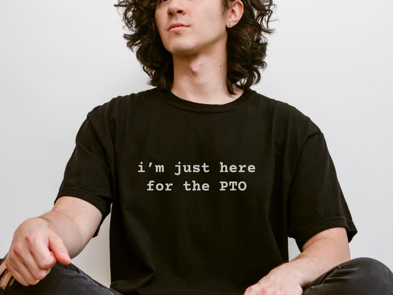 May include: A person wearing a black t-shirt with the text "i'm just here for the PTO" in white.