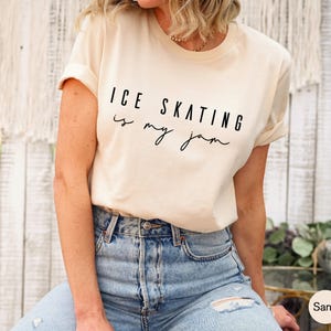 Sand-colored short-sleeve t-shirt featuring the black printed text ICE SKATING is my jam