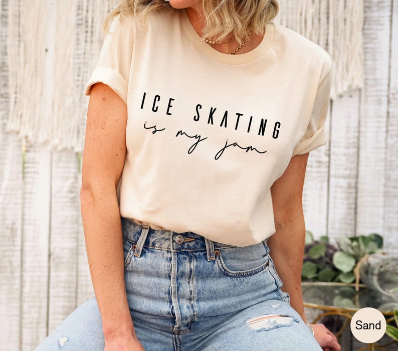 Sand-colored short-sleeve t-shirt featuring the black printed text ICE SKATING is my jam