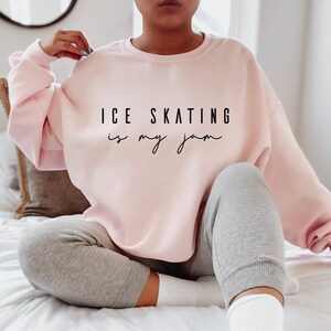 Light pink crewneck sweatshirt featuring the black text ICE SKATING is my jam printed across the chest
