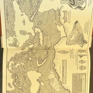 May include: An open book displays a map of prehistoric Europe during the Ice Age, with illustrations of artifacts and text. The map shows the territory of the Mamutoi winter camps and includes illustrations of a drum, horse sculpture, and mother figure.