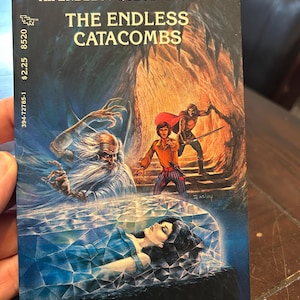 May include: A vintage paperback book titled "The Endless Catacombs" from the Dungeons & Dragons game series. The cover art features fantasy illustrations of characters in a cavern setting, with the author's name and book number visible.