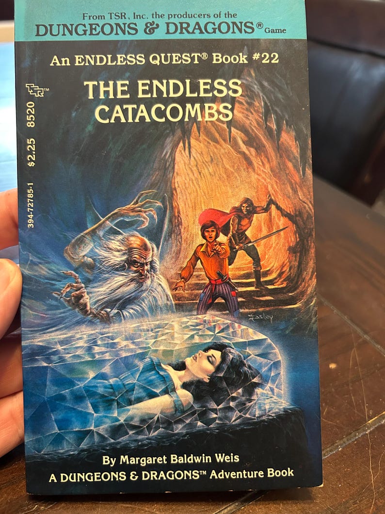May include: A vintage paperback book titled "The Endless Catacombs" from the Dungeons & Dragons game series. The cover art features fantasy illustrations of characters in a cavern setting, with the author's name and book number visible.