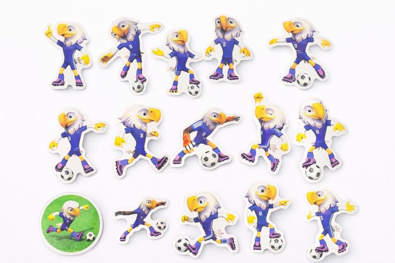 Pu&ograve; includere: Una collezione di adesivi di aquile dei cartoni animati in varie pose, tutti con uniformi da calcio blu con il numero 8. Ogni adesivo ha un pallone da calcio e uno sfondo bianco.