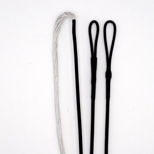 May include: Three bowstrings, one white and two black, with loops at the ends. The white bowstring is made of a braided material, while the black bowstrings are solid.