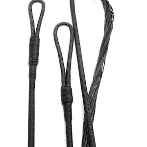 May include: Close-up of three black bowstrings against a white background. The strings have loops at the ends and are made of woven material. The strings are for archery.