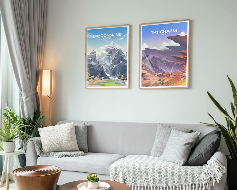 May include: Two framed posters with illustrations of landscapes from the video game Genshin Impact. The poster on the left is titled "Dragonspine" and depicts a snowy mountain range. The poster on the right is titled "The Chasm" and depicts a rocky canyon with a waterfall.