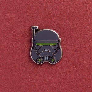 Op de afbeelding: Een zwarte en groene emaille pin met een Star Wars Stormtrooper helm.