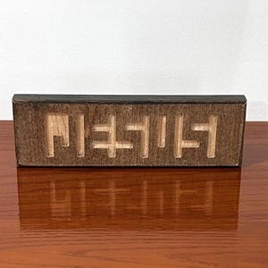 Ilusión óptica del nombre "Jesús": Tallado en madera cristiano