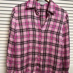 Może przedstawiać: Różowa koszula w kratę z długimi rękawami i klasycznym kołnierzem. Koszula ma dekolt w serek i wzór w kratę w odcieniach różu, czerni i magenty. Etykieta brzmi "STARINGTON".