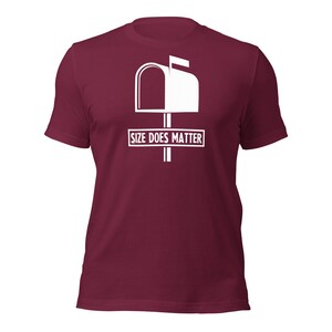 Puede incluir: Camiseta burdeos con un gr&aacute;fico blanco de un buz&oacute;n y el texto "SIZE DOES MATTER" en un rect&aacute;ngulo blanco. La camiseta est&aacute; hecha de un material suave y tiene mangas cortas.