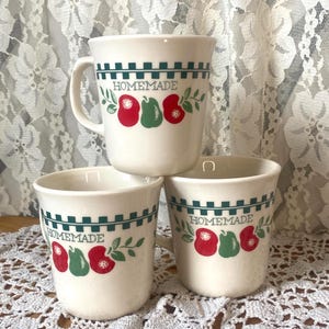 Puede incluir: Un juego de tres tazas de cerámica con un acabado mate moteado. Las tazas son de color crema, gris claro y gris oscuro. Cada taza tiene un diseño simple y minimalista.