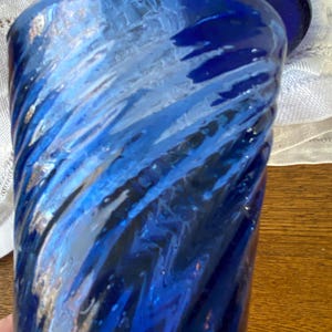 Pu&ograve; includere: Primo piano di un bicchiere blu con un design a spirale. Il bicchiere ha una superficie strutturata ed &egrave; di una tonalit&agrave; blu intenso con accenti blu e bianchi pi&ugrave; chiari. Il bicchiere fa probabilmente parte di un set.
