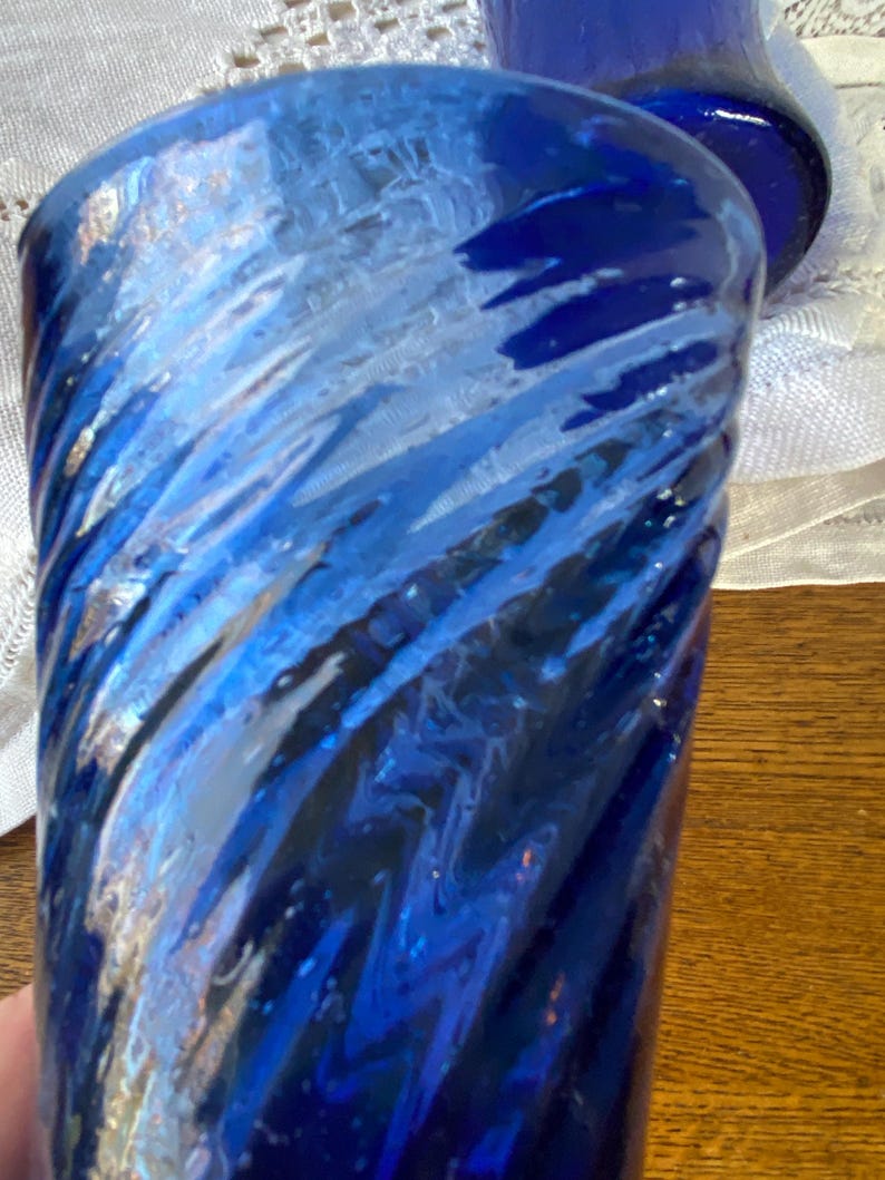 Pu&ograve; includere: Primo piano di un bicchiere blu con un design a spirale. Il bicchiere ha una superficie strutturata ed &egrave; di una tonalit&agrave; blu intenso con accenti blu e bianchi pi&ugrave; chiari. Il bicchiere fa probabilmente parte di un set.