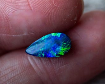 Doppietta di opale australiano da 1,6 ct con supporto in pietra di ferro. Blu e verdi brillanti e brillanti. Cabochon a forma di pera.