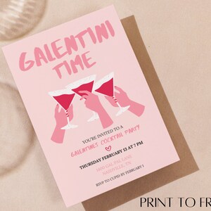 May include: Pink invitation card with the text "Galentini Time" in white lettering. The card features a graphic of three hands holding pink cocktails and the text "You're invited to a Galentines Cocktail Party" with the date and time of the party.