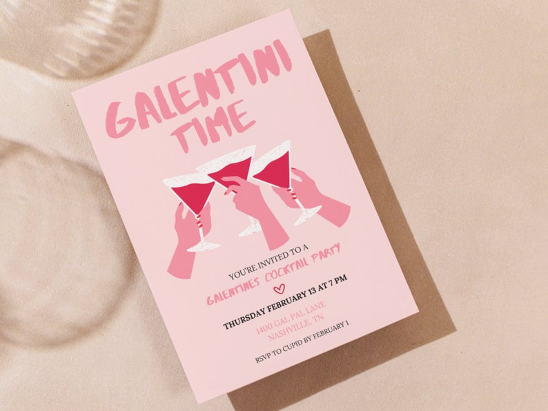May include: Pink invitation card with the text "Galentini Time" in white lettering. The card features a graphic of three hands holding up pink martini glasses with red liquid. The text below the graphic reads "You're invited to a Galentines Cocktail Party" with a heart symbol. The date, time, and location of the party are listed below the heart symbol. The text at the bottom of the card reads "RSVP to Cupid by February 1."