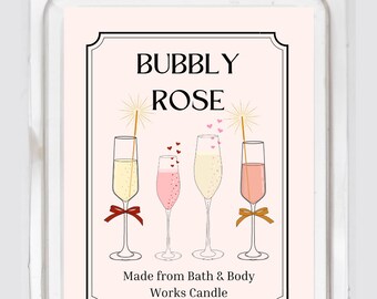 May include: A Bath & Body Works candle wax melt package with a label that reads "BUBBLY ROSE." The label features illustrations of champagne flutes with various colored drinks, ribbons, and sparklers. The package is in a clear plastic container.
