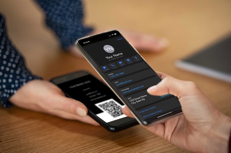Peut inclure: Deux personnes &eacute;changent des informations de contact num&eacute;riques &agrave; l'aide de leurs smartphones. L'&eacute;cran d'un t&eacute;l&eacute;phone affiche une carte de visite num&eacute;rique avec le nom d'une personne, son num&eacute;ro de t&eacute;l&eacute;phone, son adresse e-mail, son site Web et son adresse. L'autre t&eacute;l&eacute;phone affiche un code QR.