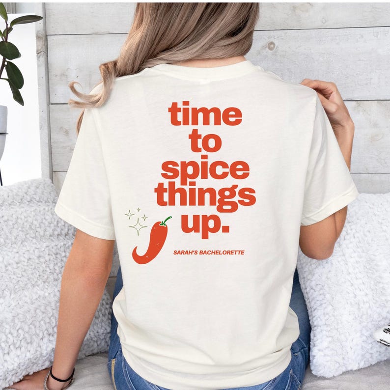 May include: White t-shirt with the text "time to spice things up." in red with a red chili pepper graphic and the text "Sarah's Bachelorette" in smaller red text.