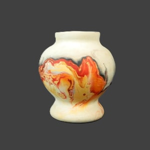 May include: A cream-colored ceramic vase with a bulbous body and a flared base. The vase features a vibrant abstract design in shades of red, orange, yellow, and black, creating a striking visual contrast. The vase has a smooth, rounded shape.