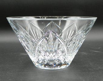 Peut inclure: Un bol en verre taillé transparent de forme triangulaire. Le bol présente un motif symétrique détaillé de formes et de lignes pointues, créant une surface texturée. Le bol est conçu pour capter et refléter la lumière, améliorant son attrait visuel.