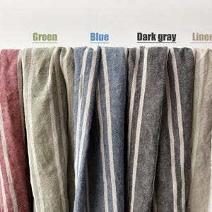 May include: Close-up of five different fabrics with vertical stripes. The fabrics are in shades of red, green, blue, dark gray, and linen beige. The word "Red", "Green", "Blue", "Dark gray", and "Linen Beige" are written above each fabric.