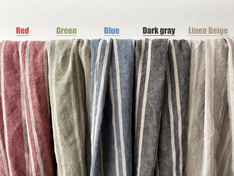 May include: Close-up of five different fabrics with vertical stripes. The fabrics are in shades of red, green, blue, dark gray, and linen beige. The word "Red", "Green", "Blue", "Dark gray", and "Linen Beige" are written above each fabric.