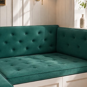 May include: A deep emerald green velvet bench cushion set featuring a tufted design with fabric-covered buttons. The cushions are rectangular and designed to fit a corner seating area, providing a soft, plush surface with a consistent texture.