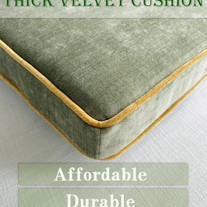 Puede incluir: Primer plano de un cojín cuadrado de terciopelo verde salvia grueso con ribete dorado. El texto "THICK VELVET CUSHION" está en la parte superior. Debajo, las palabras "Affordable", "Durable" y "Comfortable fabric".