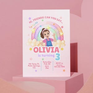 May include: A light pink birthday invitation featuring a cartoon girl, a rainbow, and the text "OLIVIA is turning 3." Additional text includes event details and RSVP information. The design incorporates stars and musical notes.