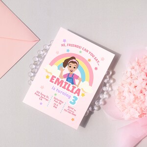 Pastel-themed birthday invitation featuring a cartoon girl inspired by Ms. Rachel, waving with a cheerful expression. The design includes a rainbow, clouds, and colorful stars on a light pink background. The text reads, 'Hi, friends! Can you say…' followed by 'Emilia is turning 3' in bold pink and purple letters. Below, event details such as date, time, location, and RSVP contact are displayed in a playful font. Simply edit, save, and print or share digitally!