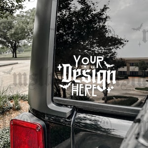 May include: A black car with a white vinyl decal on the back window that says "Your Design Here" with bats and a cross.