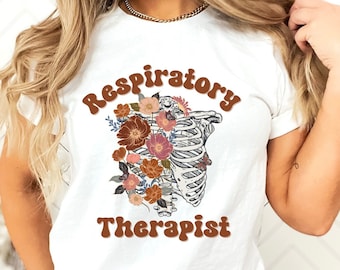 May include: White t-shirt with a brown graphic of a ribcage with flowers and the text "Respiratory Therapist" in brown.