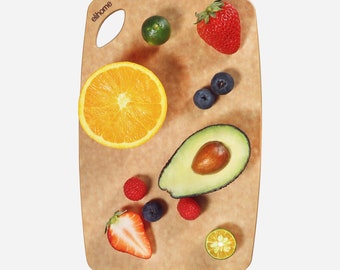 May include: A brown cutting board with a handle, featuring a variety of fruits and vegetables, including a sliced orange, avocado, lime, strawberries, and blueberries. The board is labeled "elihome".