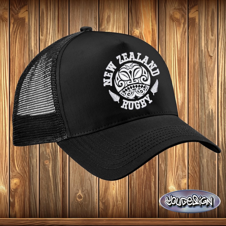May include: Black trucker hat with a white embroidered design of a Maori tribal pattern and the words "New Zealand Rugby".