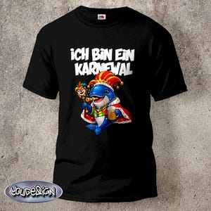Puede incluir: Camiseta negra con el texto alemán "ICH BIN EIN KARNEVAL" en blanco. La camiseta presenta una ilustración de dibujos animados de un delfín azul con una corona, sosteniendo un cetro y una jarra de cerveza, y vistiendo una túnica roja y blanca.