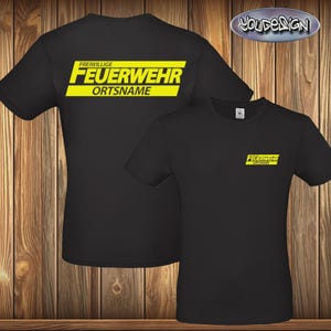 Könnte beinhalten: Schwarze T-Shirts mit gelbem Text. Ein Shirt hat den Text "FREIWILLIGE FEUERWEHR ORTSNAME" auf dem Rücken und eine kleinere Version auf der Vorderseite. Das andere Shirt hat den gleichen kleineren Text auf der Vorderseite. Die Shirts werden auf einem Holzgrund gezeigt.