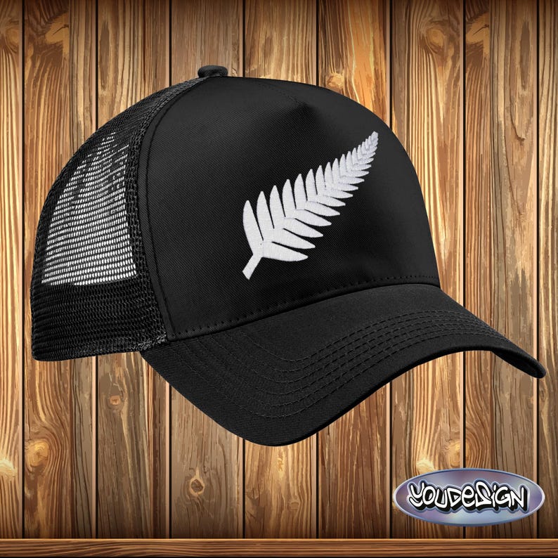 May include: Black trucker hat with a white embroidered silver fern leaf design.